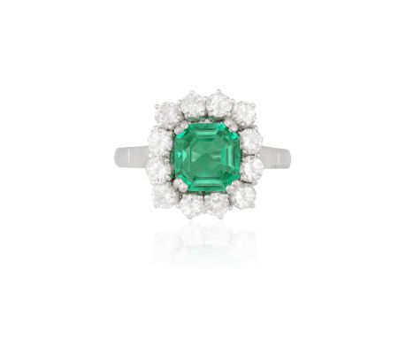 A FINE EMERALD AND DIAMOND CLUSTER RINGThe rectangular cut-cornered emerald weighing 1.51cts, within a frame of round brillia