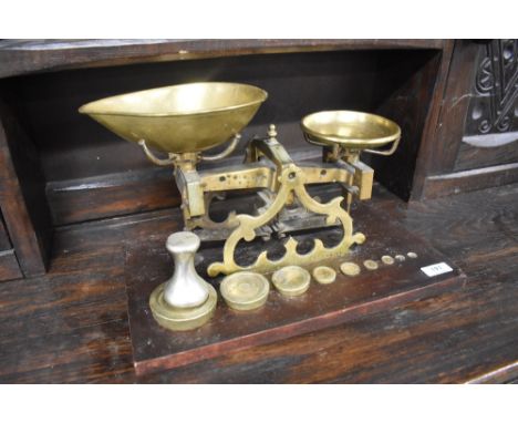 A set of brass balance scales on wood base, with weights
