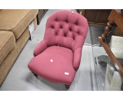 A Victorian button back nursing chair having burgundy upholstery and turned legs