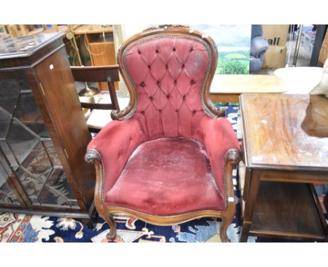 A Victorian button back armchair having dralon uphostery on scroll frame