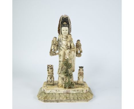 Large carved sculpture of Guanyin with children, composed of pieces of bone, in her right hand she holds upside-down a flask 