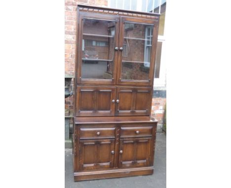Ercol elm bookcase / display cabinet with glazed top above cabinet and drawer base. Condition report: see terms and condition