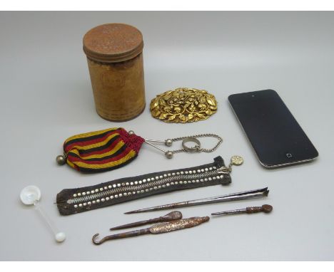 A gilt metal brooch, a miser's purse, a pick and button hook, an iPod Touch, a paste set costume zip and a fish meal tin 