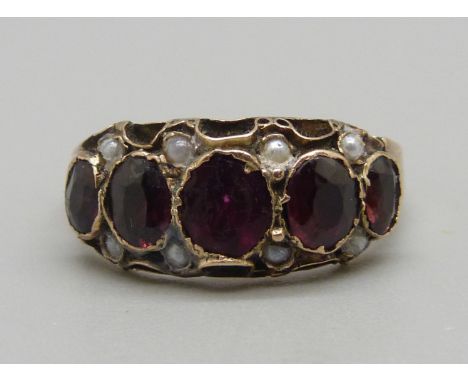 A c1900 yellow metal garnet and seed pearl ring, 1.8g, L 
