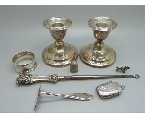 A pair of small candlesticks, one a/f, a silver vesta case, a silver pusher, a silver napkin ring, etc., (weighable silver 59