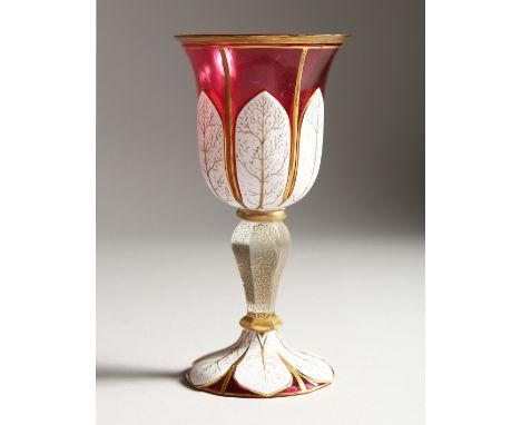 A BOHEMIAN RUBY, WHITE OVERLAY GOBLET with gilt decoration. 7.5ins high