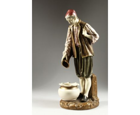  A ROYAL WORCESTER PORCELAIN FIGURE OF A TURK by Hadley, standing, pouring from a jug, into a bowl. G. Hadley, No. 394. 17.5i