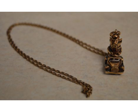 A 9ct gold comical pendant of a pig wearing a bow tie and top hat driving a motorcar on a 9ct gold chain - approx weight 13.6