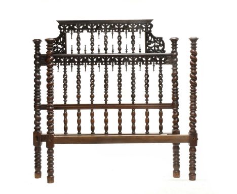 A Portuguese Colonial Hardwood Bedstead, the shaped pierced foliate carved headbord with spiral turned uprights, the footboar