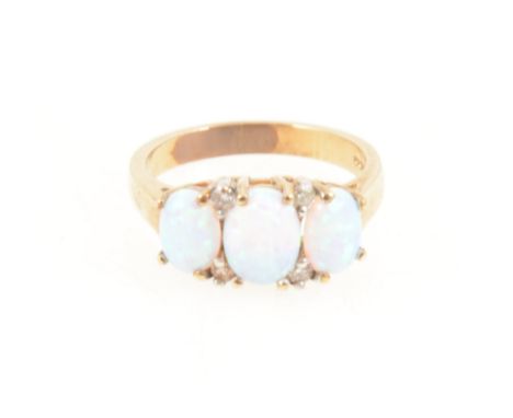 An opal three stone ring, the three oval cabochon cut opals slightly graduating in size claw set in a 9 carat all yellow gold