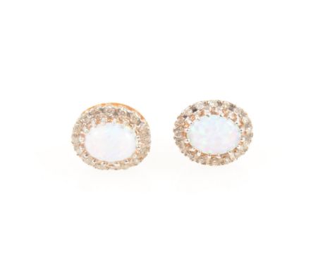 A pair of opal and diamond oval cluster earrings, an oval cabochon cut opal 8mm x 6mm claw set and surrounded by sixteen smal
