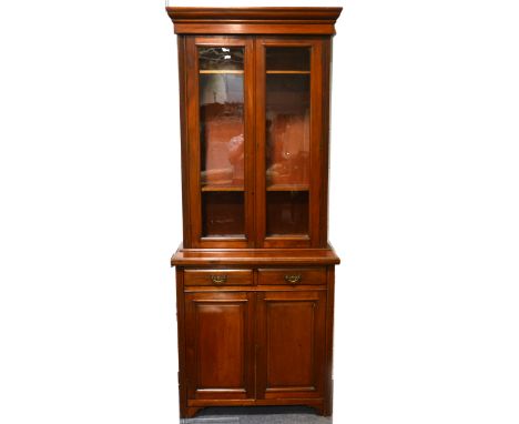 An Edwardian walnut glazed bookcase, moulded cornice, pair of glazed cupboards enclosing four adjustable shelves, above a mou