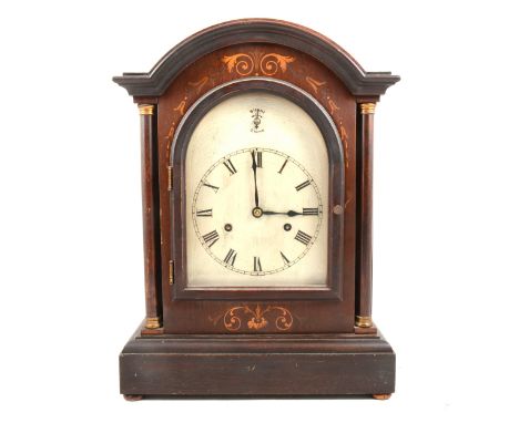 An Edwardian mahogany cased mantel clock, domed top with a moulded edge, scrolled inlay, flanked by turned columns, arched si