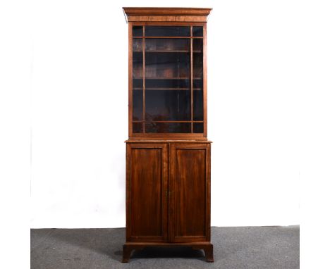 A Victorian mahogany narrow bookcase, moulded cornice above plain frieze, the upper section with a glazed door enclosing adju