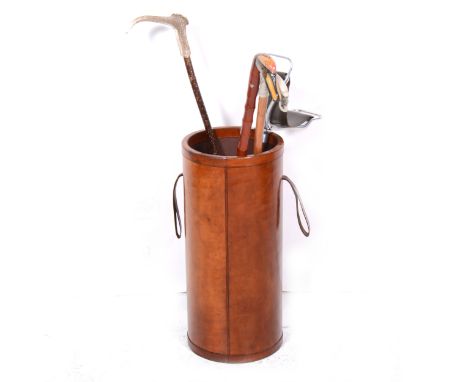 A stitched leather cylindrical stick stand, twin handles, 63cm, diameter 28cm; shooting stick; and three walking sticks.