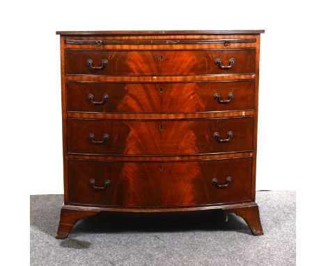 A reproduction mahogany bowfront bachelor's chest in the Georgian style, top with a reeded edge, brushing slide above four lo