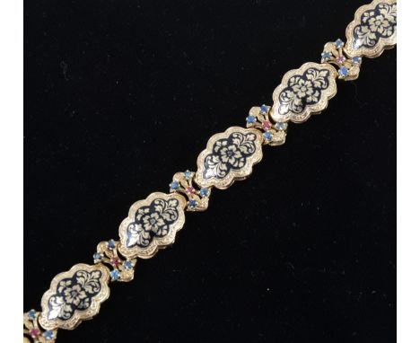 A 14 carat gold bracelet decorated in black enamel with sapphires and rubies, the six oval links inlaid with black enamel and