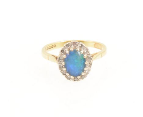 An opal triplet oval cluster ring, the oval cabochon cut opal triplet claw set and surrounded by fourteen synthetic white sto