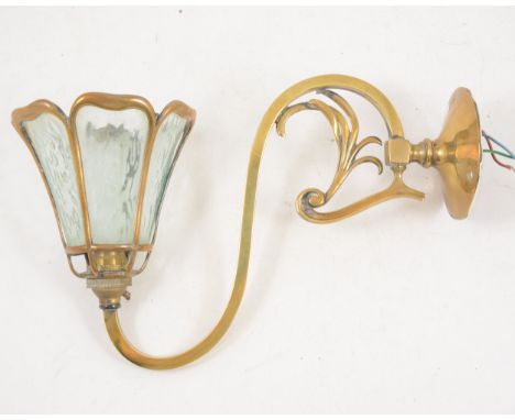 An Edwardian brass wall light, circular plaque, scrolled branch, moulded glass petal shade, 33cm x 20cm.