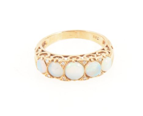 An opal half hoop ring, the five oval cabochon cut stones, graduating in size claw set in an all yellow metal reproduction ha