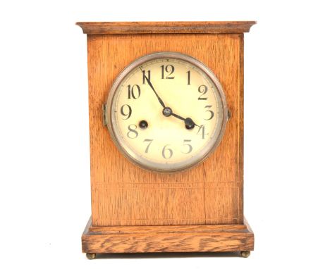 An Edwardian oak mantel clock, enamelled dial, movement striking on a gong, 29cm.