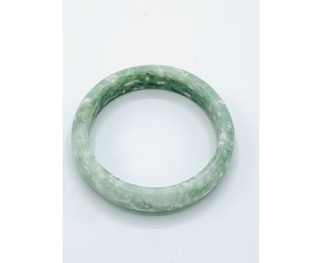 Green jade bangle, internal diameter 5.5cms.  Estimate £20-30.