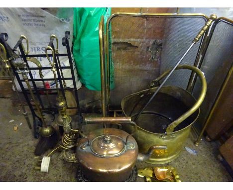 Copper kettle, brass frame spark guard, and a brass table lamp. Estimate £20-30.