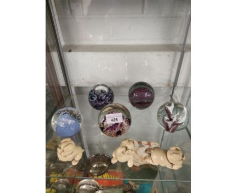 Shelf of paperweights and pig figures . 