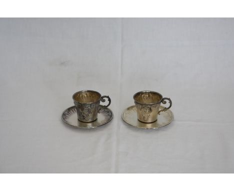 A pair of French silver plated cups and saucers with acanthus leaf scroll cast handles and gadrooned bodies.  Stamped to base
