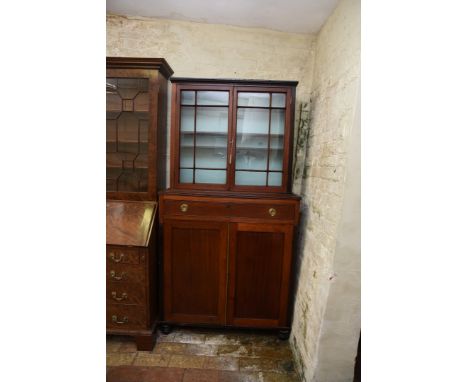 A mid 19th century mahogany china display cupboard with two glazed doors opening to reveal three interior shelves, the base w