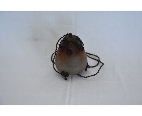 A mottled glass dome shaped lamp with applied metal mounts with scroll and leaf decoration, the base similarly decorated and 