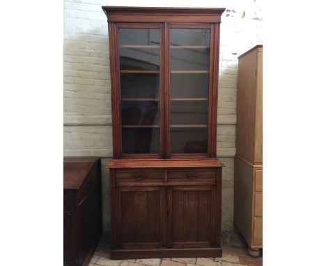 An Edwardian mahogany bookcase, the stepped pediment above twin glazed doors opening to reveal four adjustable interior shelv