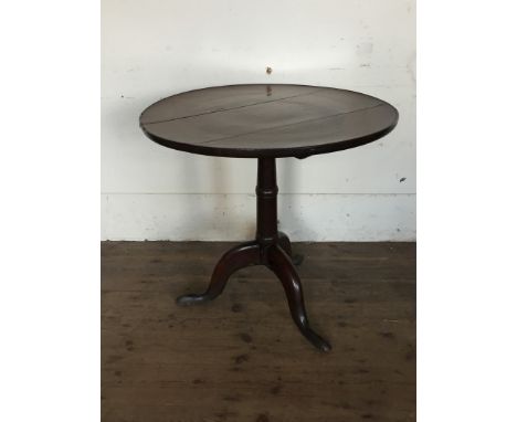 An oak circular tilt-top occasional table on turned tapering stem, tripod legs and pad feet.  29ins diameter. 