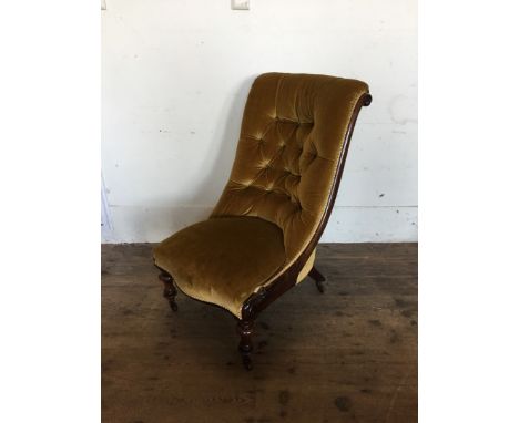 A Victorian rosewood button back nursing chair, upholstered in a gold velvet material with serpentine front seat with scrolle