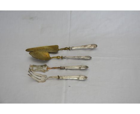 A continental white metal and gilt pair of cake servers with acanthus leaf and scroll decorated handles and gilt blades and a