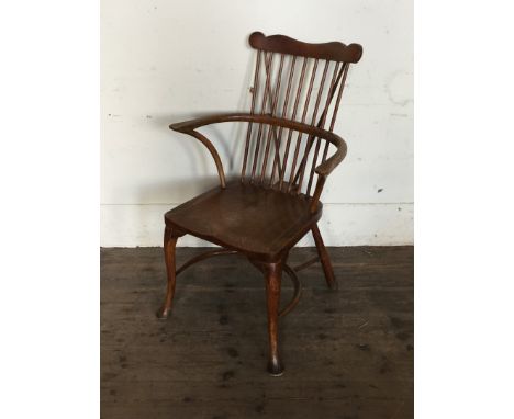 A Windsor comb back elbow chair with down-swept arm supports and solid dished seat, on cabriole legs, pad feet and with crino