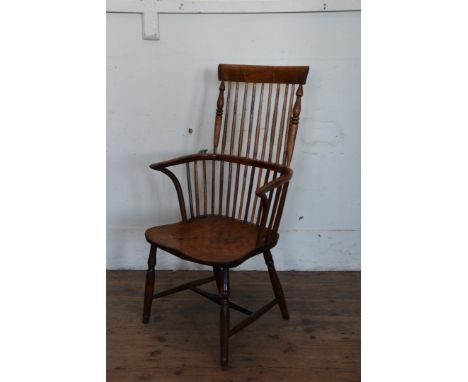 A 19th century yew Windsor comb back chair with curved cresting rail and turned spindle back, down-swept arm supports and sol