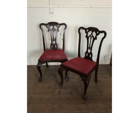 A set of six reproduction Chippendale style dining chairs with acanthus leaf decorated scrolled cresting rails, pierced scrol