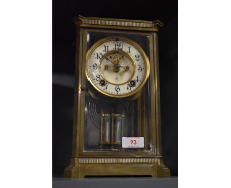 An early 20th century brass and glass cased mantel clock, having enamel face, bevelled glass doors and visible movemnent, mar
