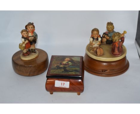 Two vintage Hummel figurines having musical movements incorporated and a similar music box.