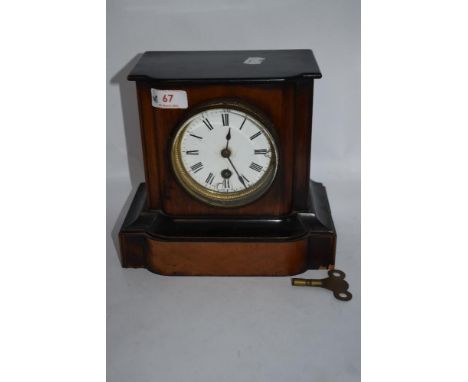 An antique mahogany cased mantel clock having enamel face with Roman numerals (AF) with key.