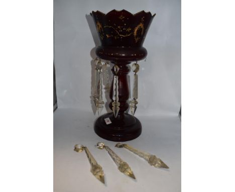 A Victorian ruby glass table lustre, with gilt heightening (worn) having five clear glass drops.