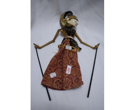 A decorative Indonesean puppet having carved wooden body and head with painted detailing.