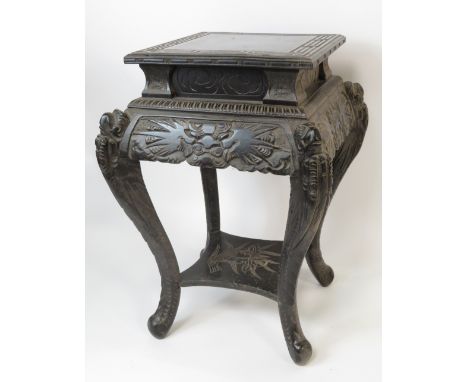 A Chinese 20th Century carved hardwood stand having square top and on four carved cabriole supports joined by a lower shelf, 