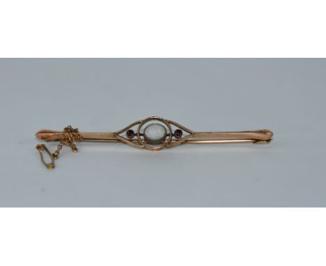 A three stone opal and garnet bar brooch, circa 1910, stamped 9ct, 6.7 cm long, 4.2 g gross, cased