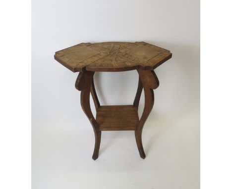 An early 20th Century occassional table having shaped moulded top with floral decoration, lower shelf and on four cabriole su