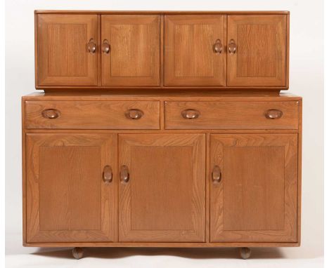 Ercol: an elm Windsor dresser, the superstructure with two pairs of cupboard doors, one opening to reveal fittings for glass 