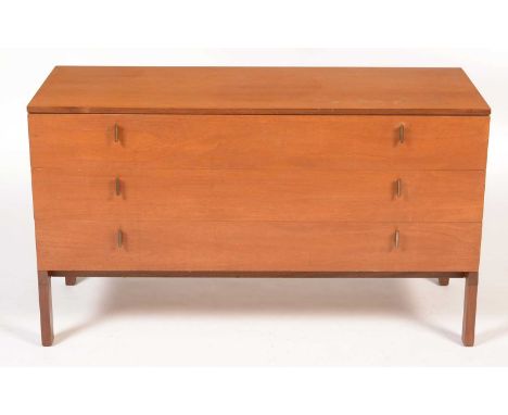 A 1960's teak 'Siesta' chest of three drawers, with vertical brass handles, on rectangular section legs, 122 x 46 x 70cms hig