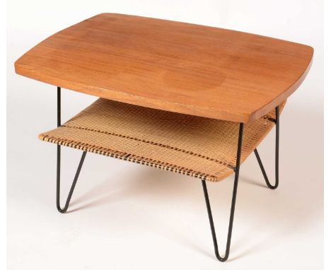 A mid 20th Century teak coffee table, the shaped rectangular top with cane magazine shelf below, on black painted wrought met