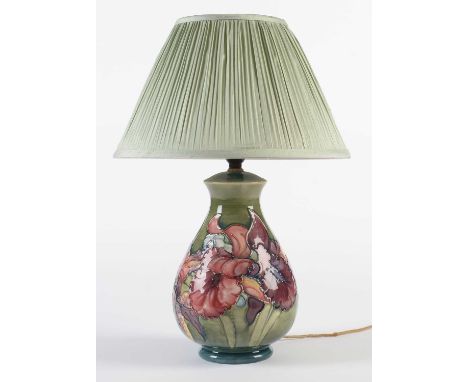 A Moorcroft lamp base of pear shape, tubed lined and picked out in colours with the Iris pattern on a graduated green ground,